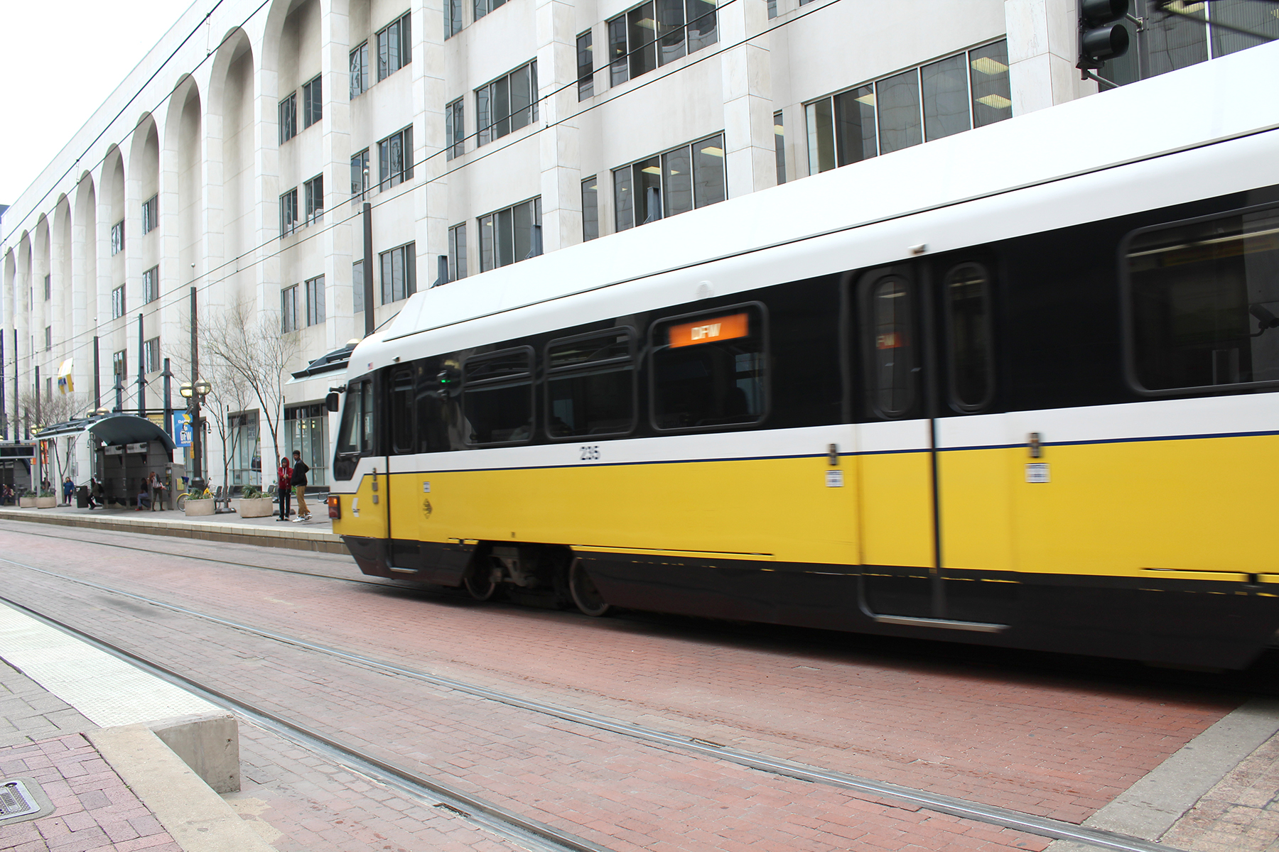 A DART Orange Line train travels by Akard Station in Dallas.